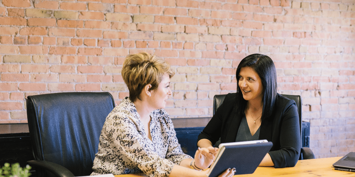 women sitting on a desk